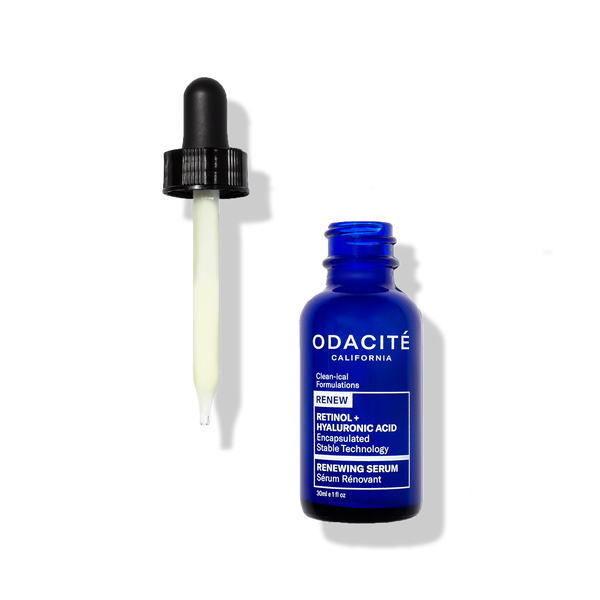 Odacité Renewing Serum Retinol + Hyaluronic Acid in a blue bottle with a dropper holding pale yellow liquid on a white background.