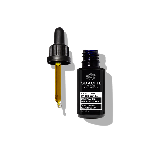 Dark Odacité bottle with dropper dispensing An Autumn On The World 15% Vitamin C Serum, on a white background.