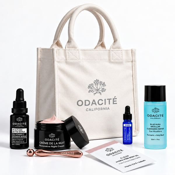Odacité Fall Reset Box with Vitamin C creams, serum, cleansing water, tool, and a neutral tote bag arranged together.