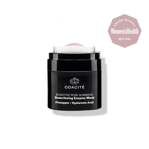 Odacite Bioactive Rose Gommage Mask in a black jar, labeled with product name, next to pineapple and hyaluronic acid elements.