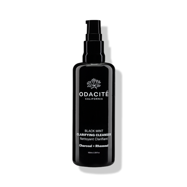 Black bottle of Odacite Black Mint • Charcoal + Rhassoul Clarifying Cleanser with pump dispenser on a white background.