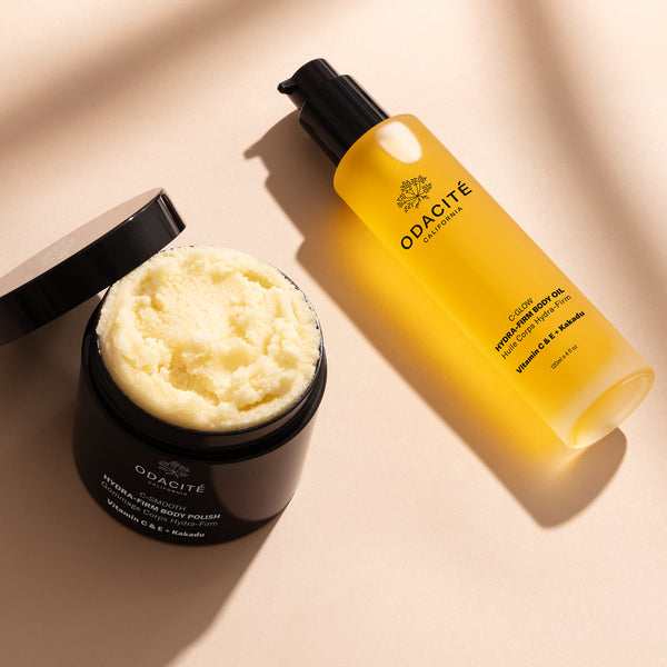 Odacité Hydra-Firm Full Body Duo, C-Glow & C-Smooth, with Vitamin C and Kakadu Plum in labeled pump bottles on a plain background.