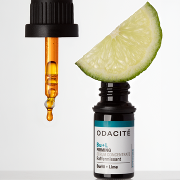 Odacité Structural Reset Duo with an amber serum dropper and a lime slice arranged together.