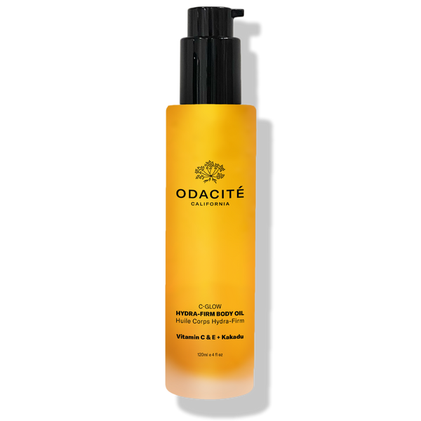 Odacité C-Glow Hydra-Firm Body Oil with Vitamin C & E + Kakadu in a yellow bottle with black pump, set against a white background.
