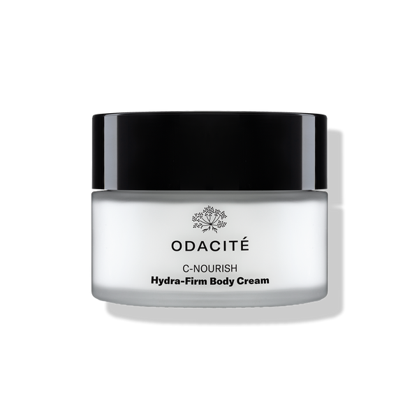 Odacité C-Nourish Hydra-Firm Body Cream with Vitamin C & E + Kakadu Plum in a jar with a black lid on a light background.
