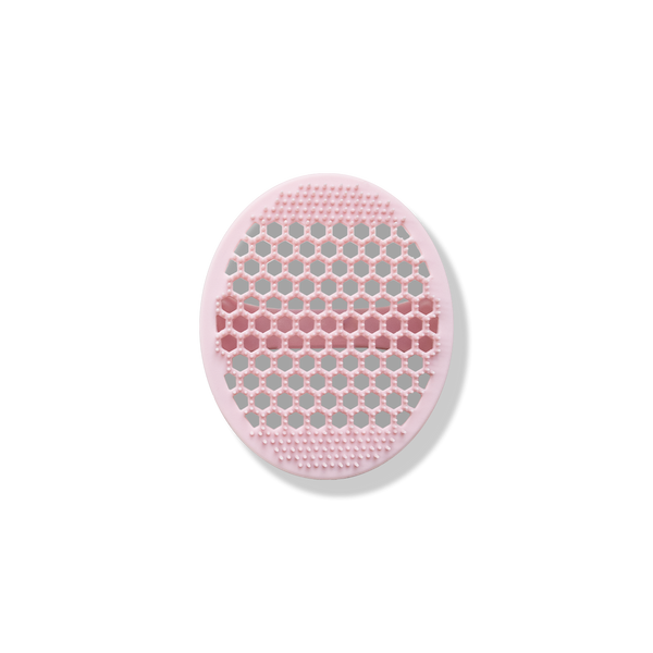 The Odacité Pore & Face Cleansing Brush is a round pink silicone mat with textured bristles.