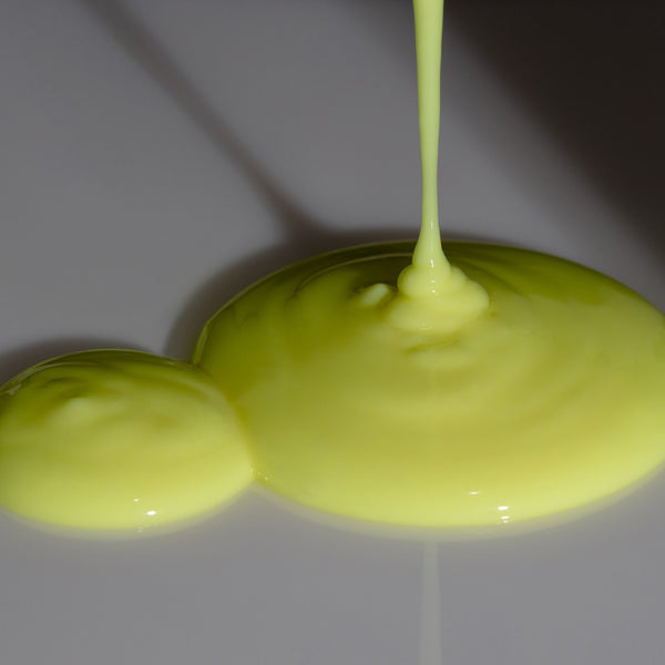 Derm-Restore Super Serum by Odacité with Edelweiss Extrême® shown as glossy yellow puddles on a surface.