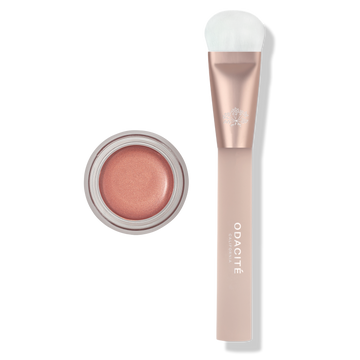 Makeup product with a brush and container on a white background