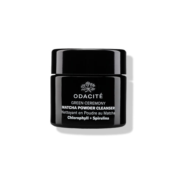 Odacité Green Ceremony Cleanser with chlorophyll and spirulina matcha powder in a black jar on a white background.