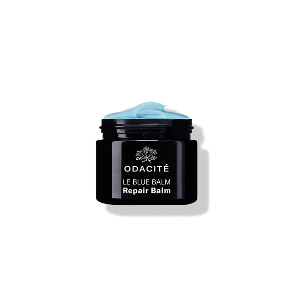 Odacite le Blue Balm Black jar labeled Blue Chamomile + Shea Butter Repair Balm for dry skin on a white background.
