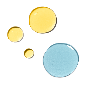 Three yellow oil droplets and one large blue liquid droplet for the Odacité Mature Skin Double Cleansing Set.