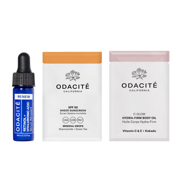 Odacité May Deluxe Samples: blue serum dropper, white sunscreen sachet, and orange body oil sachet standing upright.