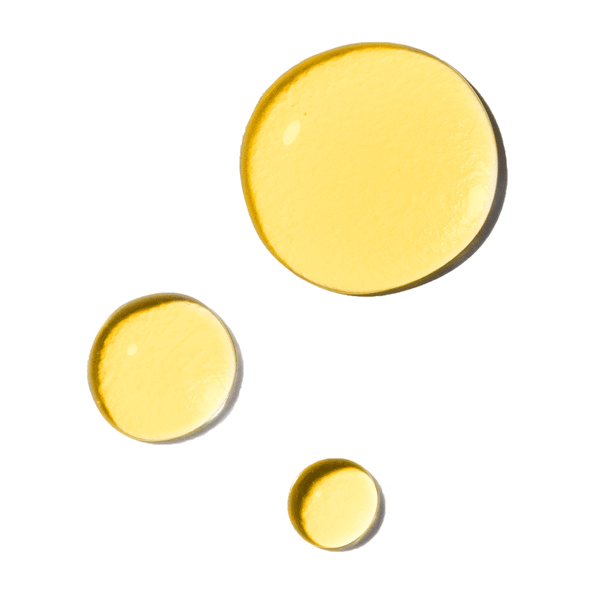 Three yellow drops of Odacite Montana Harvest Hemp + Sea Buckthorn Omega Oil Cleanser on a light gray background.