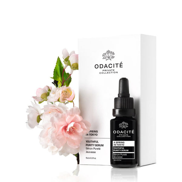 Odacite Youthful Purity Serum A Spring in Tokyo with box, next to pink cherry blossoms on a white background.