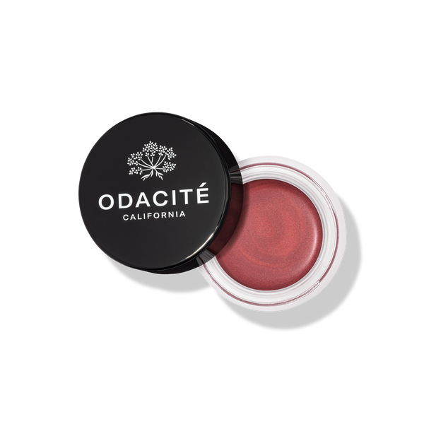 Open jar of Odacite blush with black lid on a white background