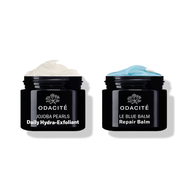 Odacité Smooth & Soothe Duo with two open black jars: daily exfoliant (white cream) and repair balm (blue cream).