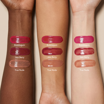 Three arms with different skin tones displaying Odacité SPF 40 Nourishing Lip Serum swatches in Bubblegum, Jazz Berry, and True Nude.