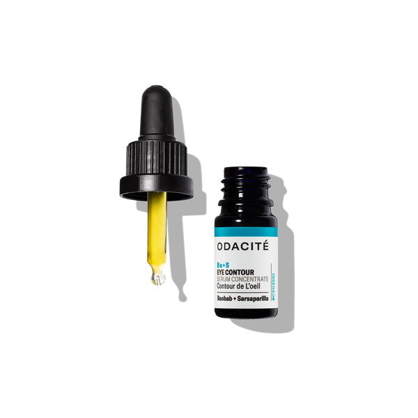 Dropper with yellow serum next to open Odacité Ba+S Eye Contour Serum Concentrate on a white background.