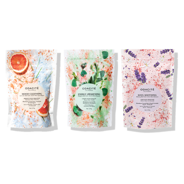 Odacite’s Relax & Recenter Bath Set with three jars of Ayurvedic bath soaks, shown against colorful botanical backgrounds.