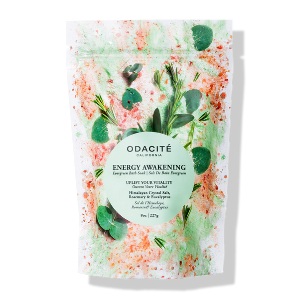Odacite Energy Awakening Bath Soak with Himalayan salt, rosemary, and eucalyptus in a clear jar with minimal label design.