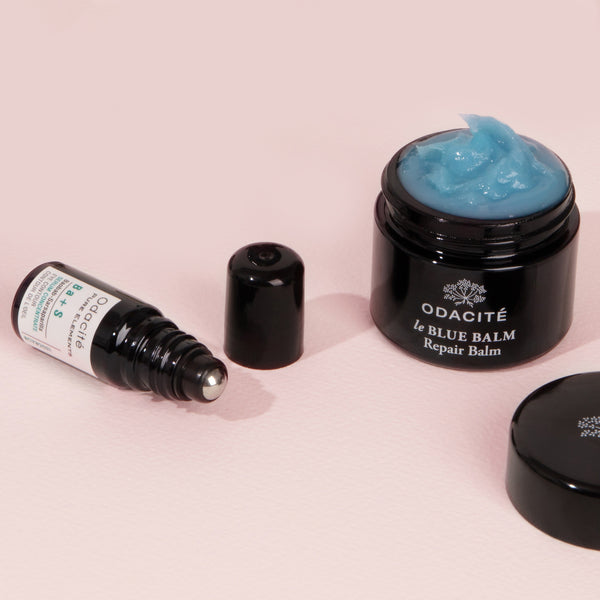 Odacité Eye Repair Duo jars with open lids on a light pink surface.