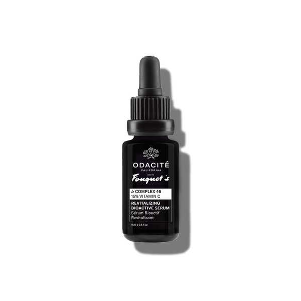 Black dropper bottle of Odacité Le Complex 46 Revitalizing Bioactive Serum, 15% Vitamin C, with white label on gray background.